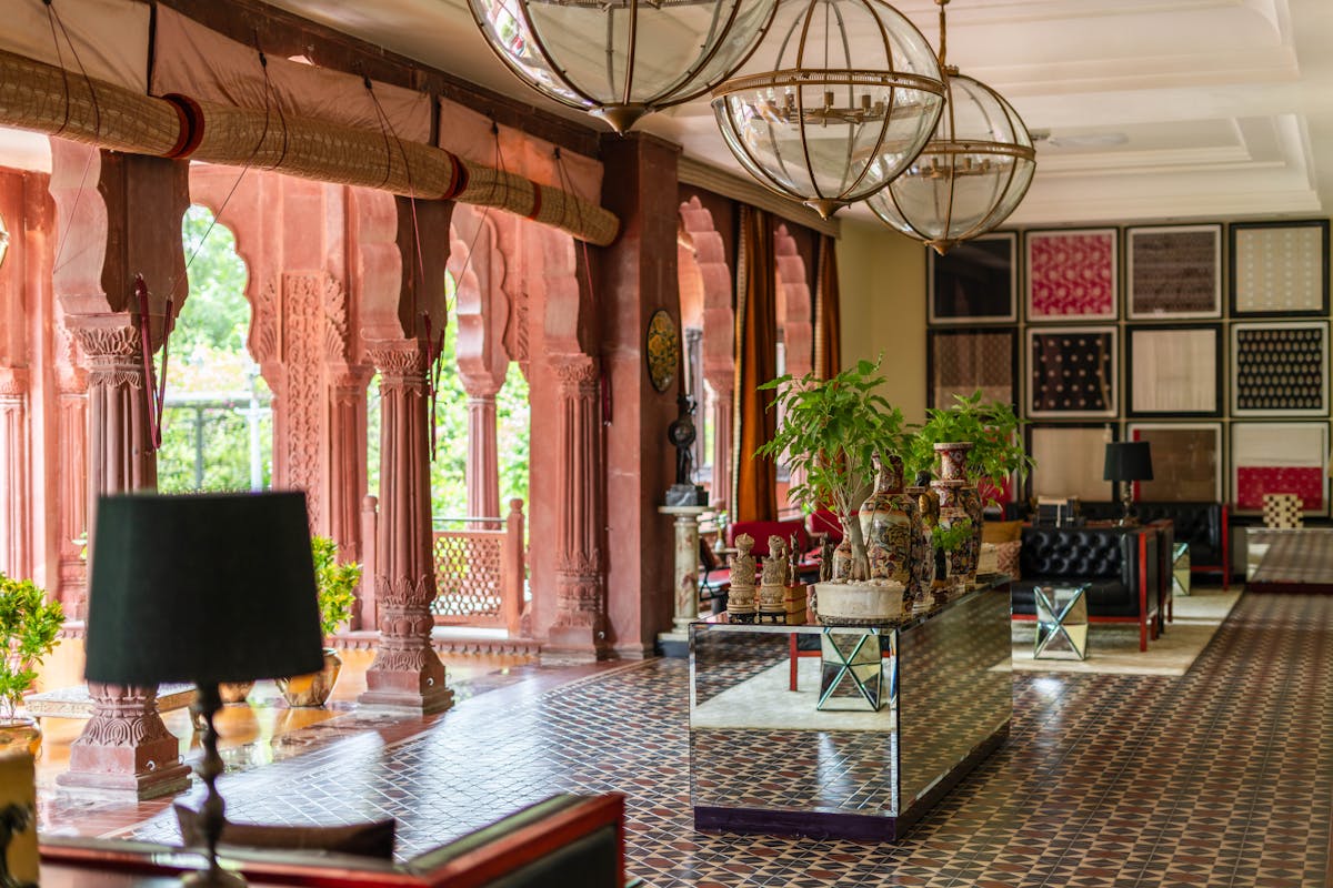 Hotel-Lobby mit Säulen, Kugel-Pendelleuchten und gemustertem Marmor-Boden — Beispielbild Hospitality-Reinigung.